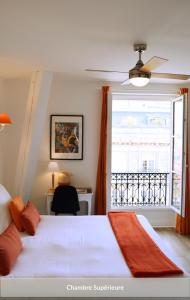 a bedroom with a bed and a large window at Hôtel & Espace Bien-être La Maison du Lierre in Biarritz