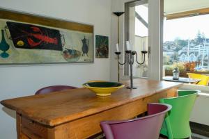a dining room with a wooden table and colorful chairs at Seewohnung 2 in Spiez