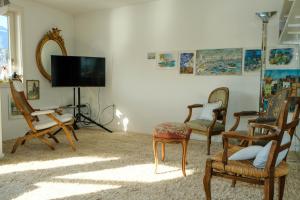 a living room with chairs and a flat screen tv at Seewohnung 2 in Spiez