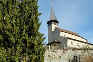 a church on top of a wall with a tree at Seewohnung 2 in Spiez