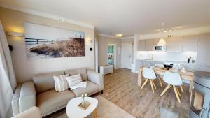 ein Wohnzimmer mit einem Sofa und einer Küche in der Unterkunft Beach'n'Sea Wohnung 3 in Grömitz