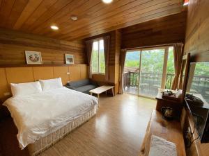 a bedroom with a bed and a couch in a room at Spring Ground Resort in Ren'ai