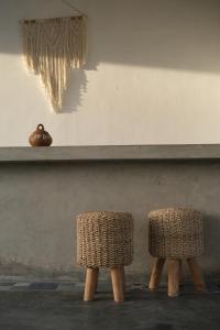 two wicker chairs sitting in front of a shelf at Suku Lifestyle Hotel & Villas in Selong Belanak