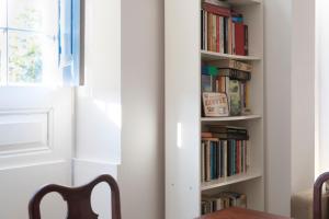 a book shelf filled with books and a wooden table at Pensão Destino in Castelo de Vide