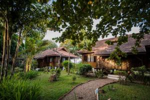 a house with a garden in front of it at La Folie Lodge in Champasak