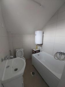 a white bathroom with a tub and a toilet at Guest house Vlahovic in Kolašin +25 photos