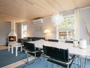 Bøtø ByにあるThree-Bedroom Holiday home in Væggerløse 6のリビングルーム(テーブル、椅子、暖炉付)