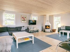a living room with a couch and a fireplace at 6 person holiday home in Væggerløse-By Traum in Marielyst