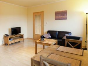 a living room with a couch and a tv at Apartment in Rommersheim with countryside view in Prüm