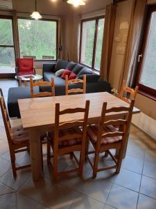 uma sala de estar com uma mesa de madeira e cadeiras em Börzsöny Vendégház em Nagymaros