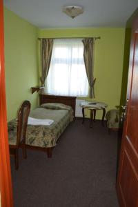 Pątnów的住宿－Jurajska Perła，一间卧室配有一张床、一张桌子和一个窗户。