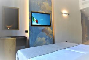 una camera con letto e TV a schermo piatto a parete di Mokinba Hotels King a Milano