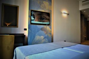 una camera con letto e una foto di un occhio di Mokinba Hotels King a Milano