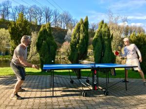dos hombres jugando ping pong en una mesa de ping pong en Apartment direkt an der Waldnaab, en Neustadt an der Waldnaab