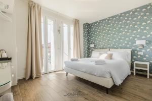 a bedroom with a large white bed with a floral wall at CASA BACI - Soggiorno nel Gusto in Colà di Lazise