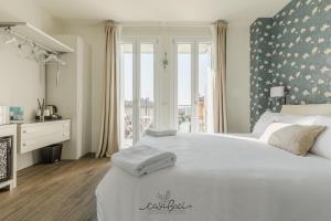 a bedroom with a large white bed and a window at CASA BACI - Soggiorno nel Gusto in Colà di Lazise