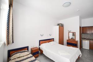 1 dormitorio con 2 camas y espejo en Coralli Apartments en Pefki Rhodes