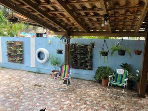 un patio con 2 sillas y una pared con plantas en Magia do Mar Hostel, en Florianópolis