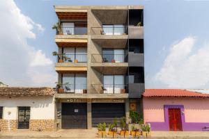 an apartment building with colorful doors and windows at Hotel Momotus in Tuxtla Gutiérrez
