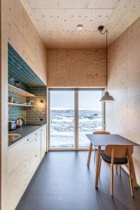 a kitchen with a table and a view of the ocean at Aska, Modern Cabin in Myvatn