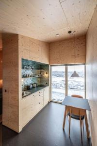 a kitchen with a table and a large window at Aska, Modern Cabin in Myvatn