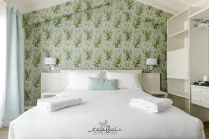 - une chambre avec un lit blanc et un mur vert dans l'établissement CASA BACI - Soggiorno nel Gusto, à Colà