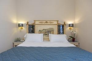 łóżko z 2 białymi poduszkami i niebieskim kocem w obiekcie Hotel Donatello we Florencji