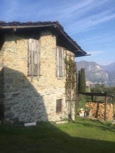 una casa de piedra con una pared de piedra y césped verde en Aqua&Co Bellagio - Eco conscious stay en Bellagio