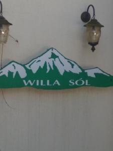 ein Schild hängt an einer Wand mit schneebedeckten Bergen in der Unterkunft Willa Sól in Rajcza