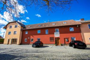 a red building with two cars parked in front of it at Penzion Vion in Pilsen