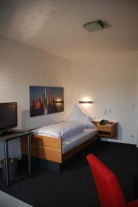 a bedroom with a bed and a desk and a television at die Villa in Bad Wörishofen