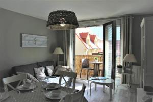 a living room with a couch and a table at Plaisirs du bord de mer in Camiers