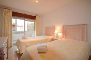 1 dormitorio con 2 camas y ventana en Apartamentos Paula Bela by Garvetur en Quarteira