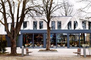 dwie ławki przed budynkiem z oknami w obiekcie Artisan Park w mieście Kostrzyn nad Odrą
