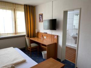 a hotel room with a desk and a sink at Hotel Kaiserhof in Lehrte