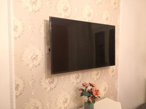 a television on a wall with a vase with flowers at B&B Villa Lilla in San Benedetto del Tronto