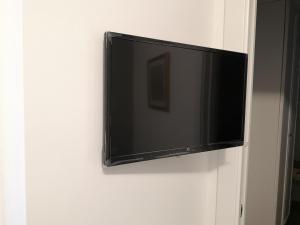 a flat screen tv hanging on a wall at B&B Villa Lilla in San Benedetto del Tronto