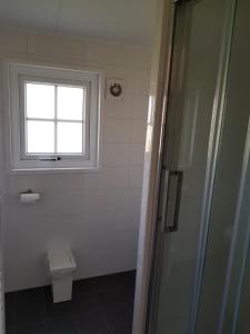 La salle de bains est pourvue de toilettes et d'une fenêtre. dans l'établissement De Bijsselse Enk, Noors chalet 7, à Nunspeet