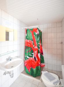 a bathroom with a shower curtain with a flamingo on it at Palm Bay Hotel in Pefki