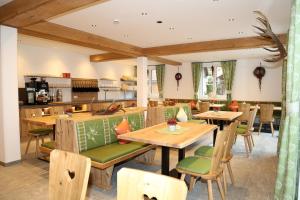 a restaurant with wooden tables and green seats at Schmiedgut in Haus im Ennstal