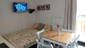 um quarto com uma mesa e um sofá e uma mesa e cadeiras em apartmán Pod Lapkou em Kvilda