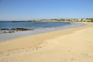 a sandy beach with a view of the ocean at Hotel Restaurant De La Plage in Audierne