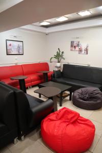 una sala de estar con sofás y mesas rojos y negros en Travel Inn Достоевская, en Moscú