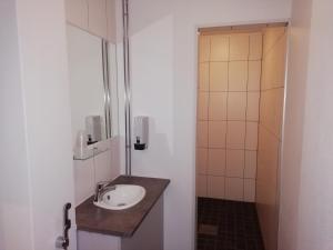 a bathroom with a sink and a shower at Hotel Turistihovi in Kouvola