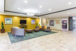 a lobby with a waiting room with couches and a tv at Candlewood Suites Aurora-Naperville by IHG in Aurora
