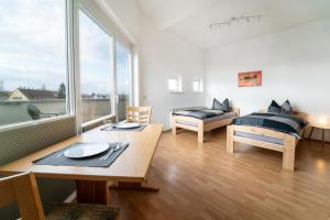 uma sala de estar com uma mesa e uma cama em Pension Schweizer em Laupheim