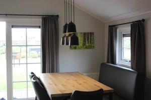 a dining room with a wooden table and a window at De Bijsselse Enk, Noors chalet 2 in Nunspeet