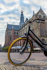uma bicicleta estacionada em frente a um grande edifício em Boutiquehotel Staats em Haarlem