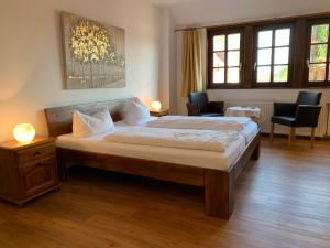 a bedroom with a large bed and two chairs at Hotel Weingärtner in Mannheim