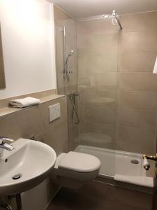 a bathroom with a shower and a toilet and a sink at Hotel Weingärtner in Mannheim